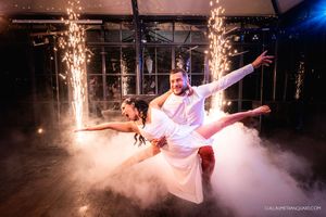 Couple performs dramatic wedding dance with sparklers and fog effects on dance floor.