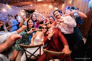 Energetic wedding reception with guests dancing and celebrating in a rustic venue.