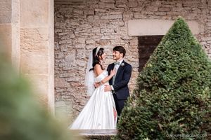 Romantic moment captured against a rustic stone wall backdrop.