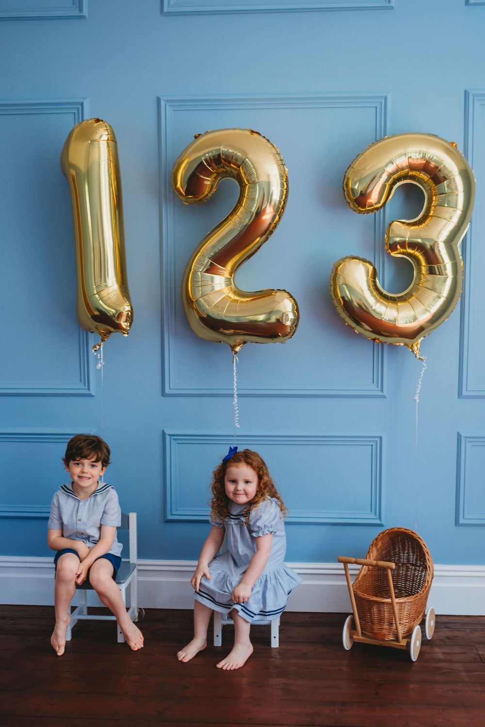 A series of photos showing two children sitting against a blue wall with large gold number balloons showing a countdown.
