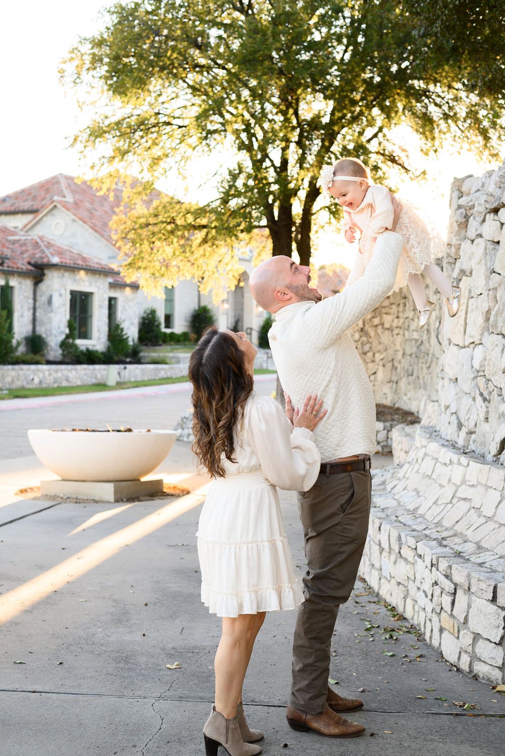 Sweet moment captured outside stone building during golden sunset.