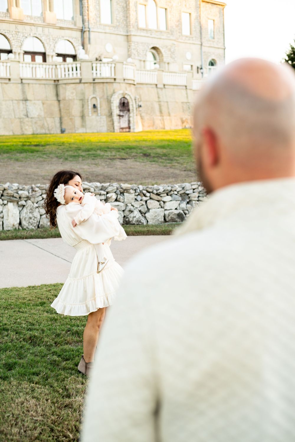 Romantic outdoor portrait in front of stone building during golden hour.