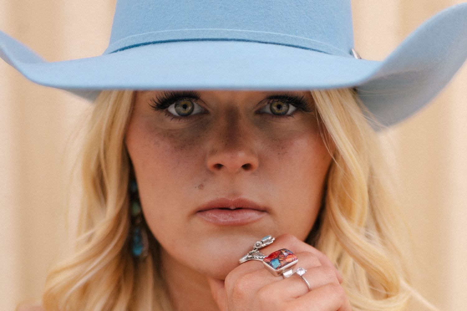 Close-up fashion shot featuring turquoise jewelry and light blue cowboy hat. Lake Geneva Wisconsin for Pro-Hats