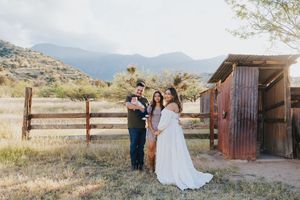 Desert landscape photoshoot featuring family members and rustic wooden structures.