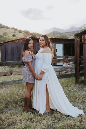 White flowing dresses contrast beautifully against rustic desert backdrop during family photoshoot.