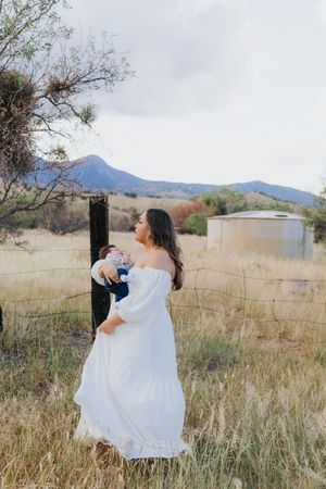 White dress flowing in the breeze during desert photoshoot with mountains in background.