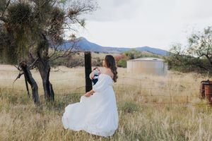 Desert landscape photoshoot with mountains and dry grass in the background.
