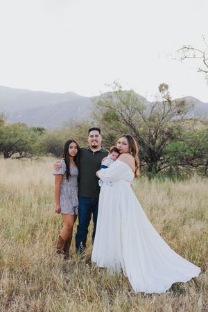Desert family photoshoot with mountains and tall grass in natural lighting.