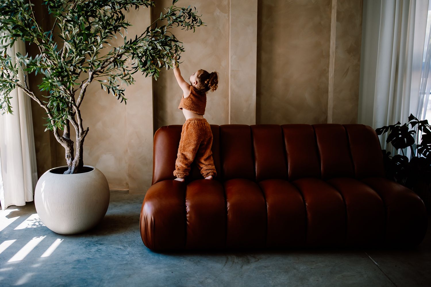 Photographer's daughter reaching up, captured with the warm and heartfelt approach behind Birdie + May Photography.