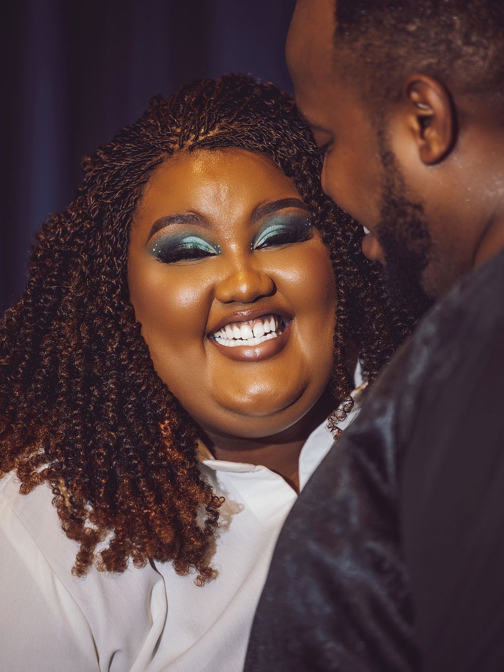 Close-up portrait showing sparkling makeup and genuine happiness.