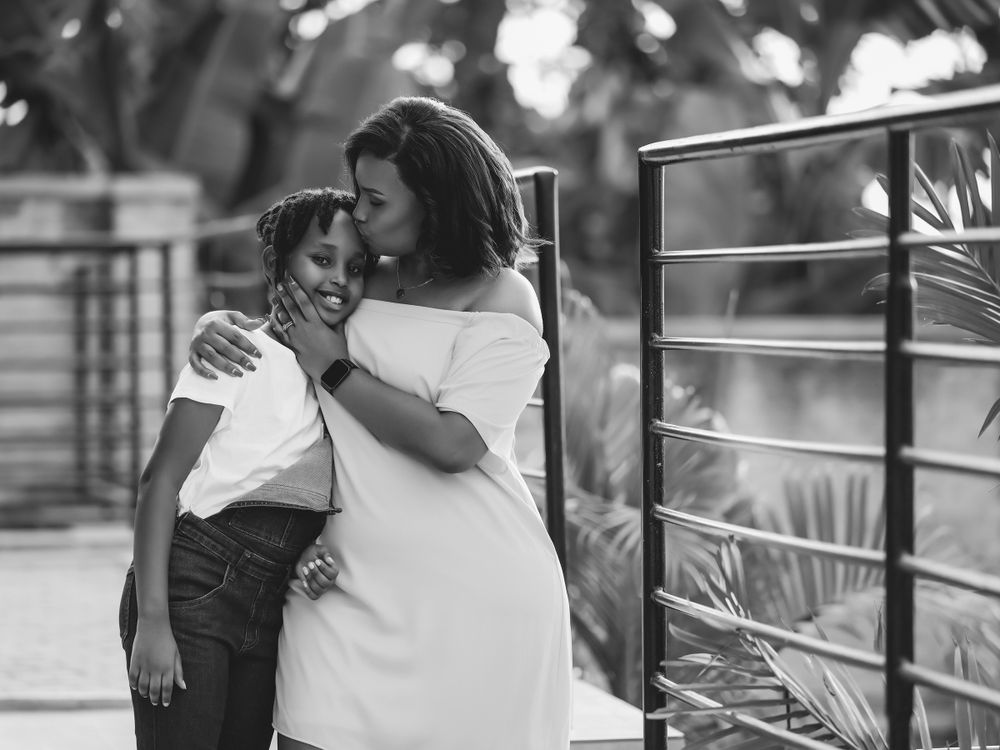 Intimate black and white portrait of two people sharing a tender moment on a patio.