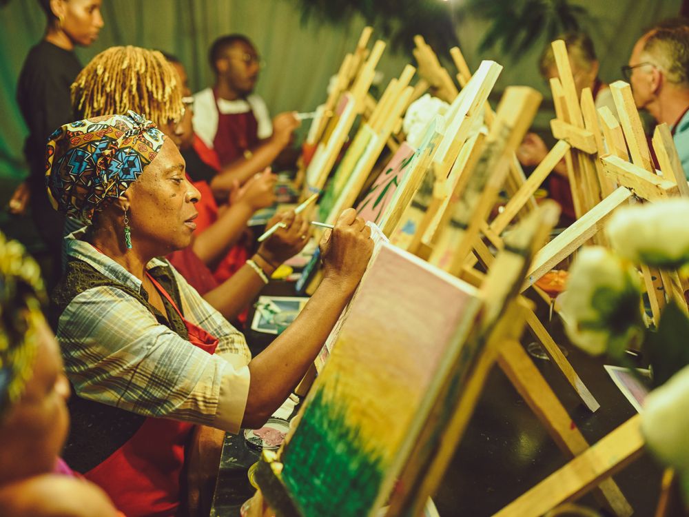 Artist working on a painting at an outdoor evening art class.