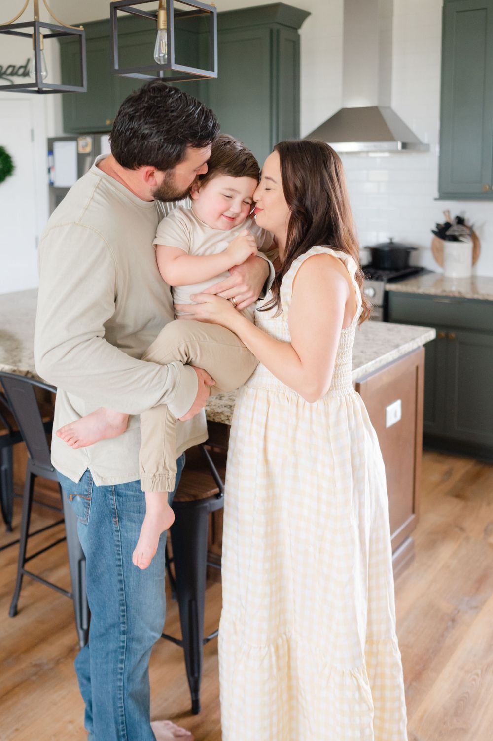 Romantic couple sharing tender moments in a modern kitchen with hardwood floors.