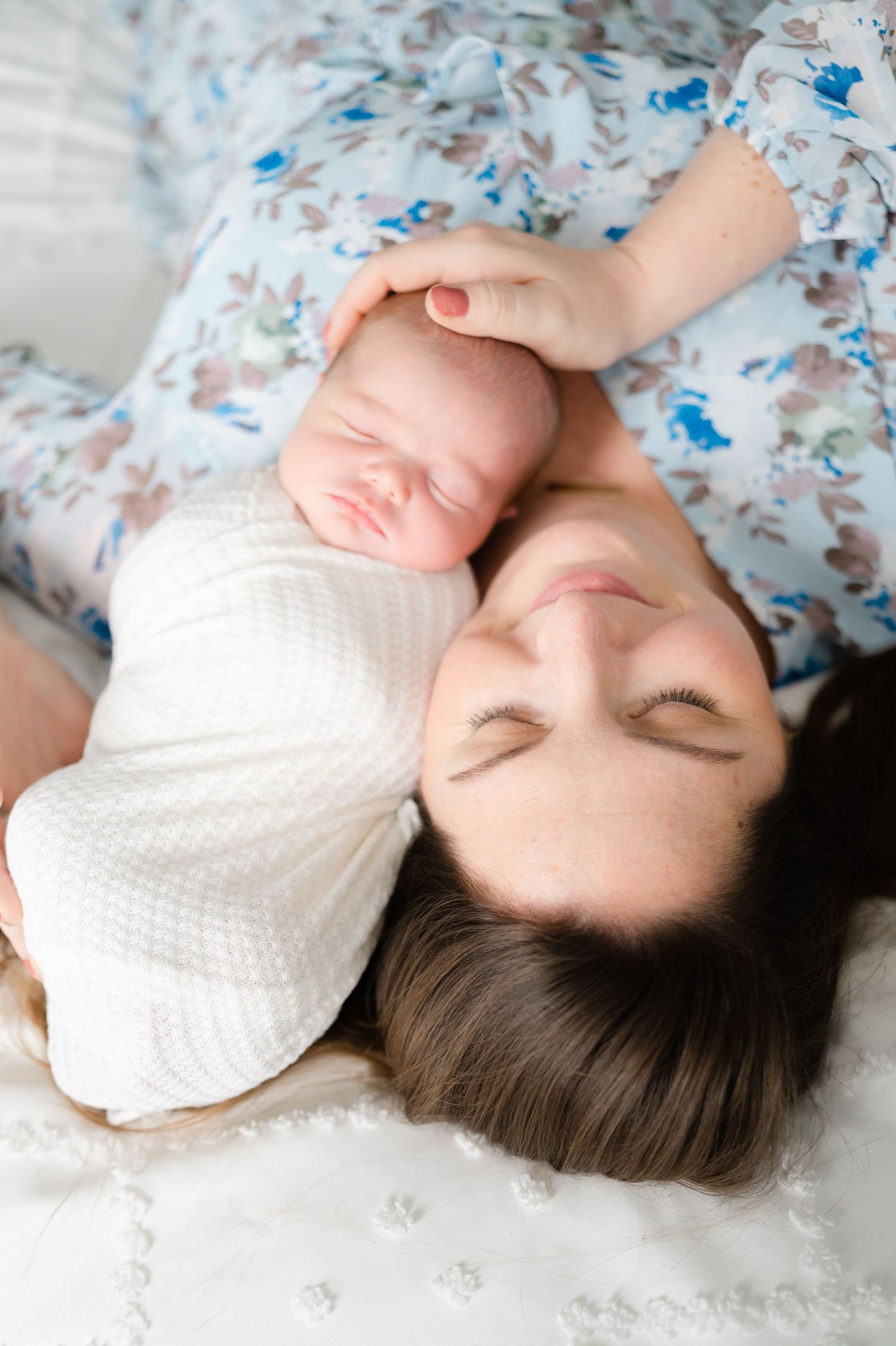 Close-up shots of a baby resting on floral patterned bedding.
