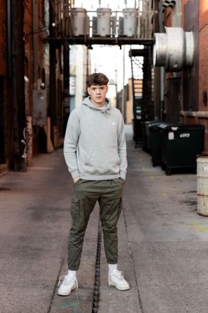 Urban photoshoot featuring casual streetwear in an industrial brick setting.