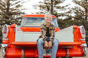 Lifestyle portraits featuring vintage red pickup truck with pine trees in background.
