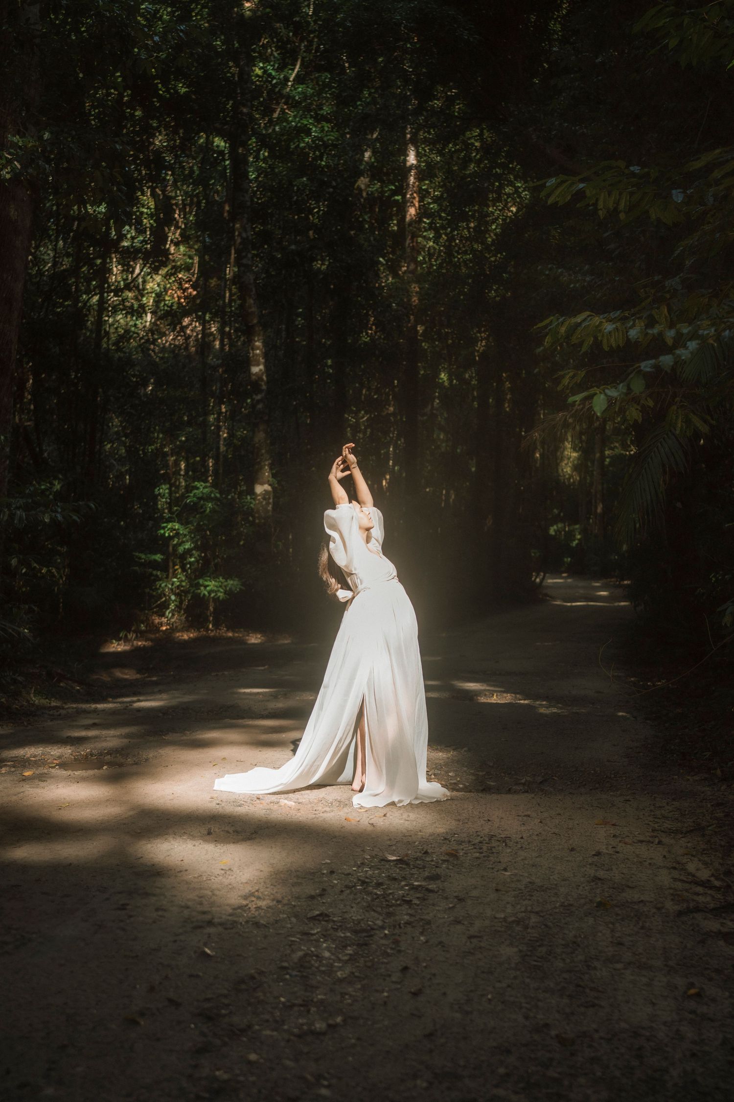 Ethereal wedding photo sequence showing figure in flowing white dress dancing in sunlit forest clearing.
