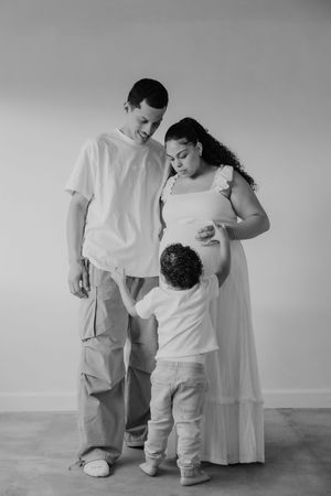 Black and white photographs showing tender moments between parent and child in minimalist setting.