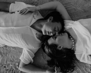 A person in a white shirt lies down in a dramatic black and white photoshoot series.