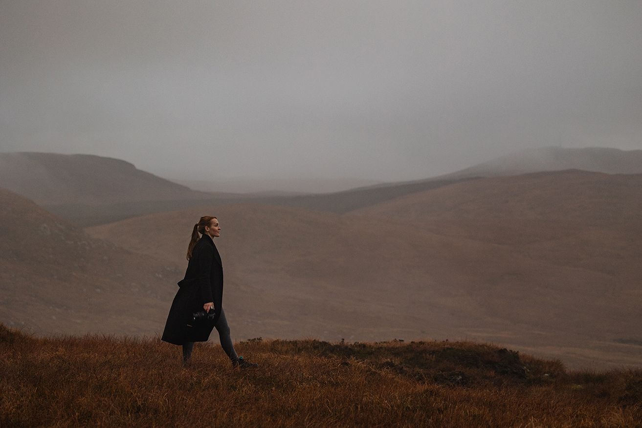 photographer walking up the Diamond hill in late autumn, holding a photo camera in one hand