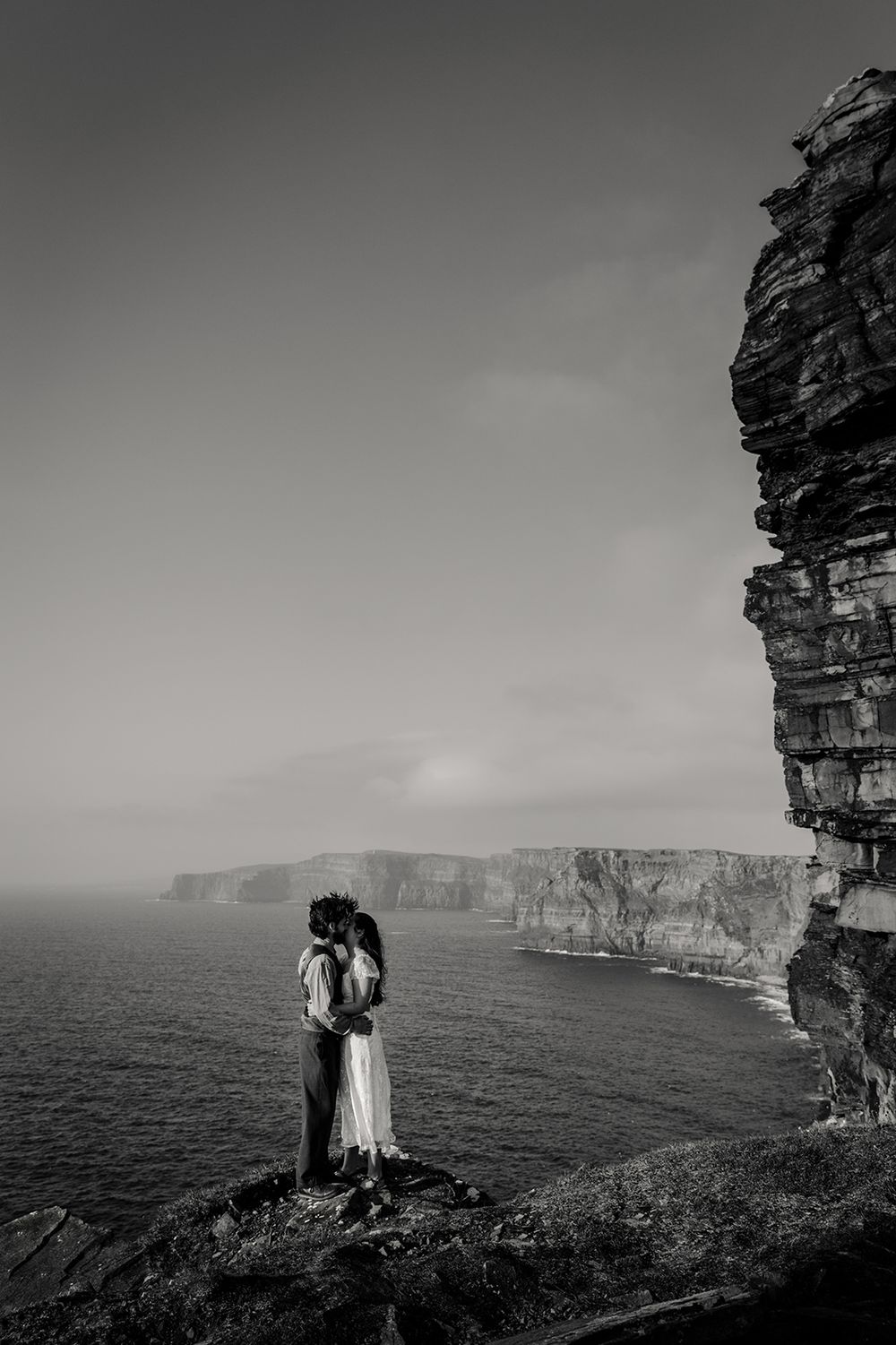 Couple standing at the edge of Cliffs of Moher during their adventure elopement in Ireland