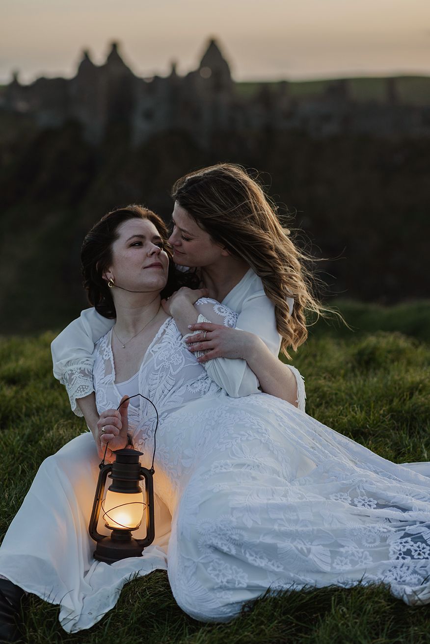 couple holding each other close by the Dunluce castle, Causeway coast in Northern Ireland during their adventure elopement