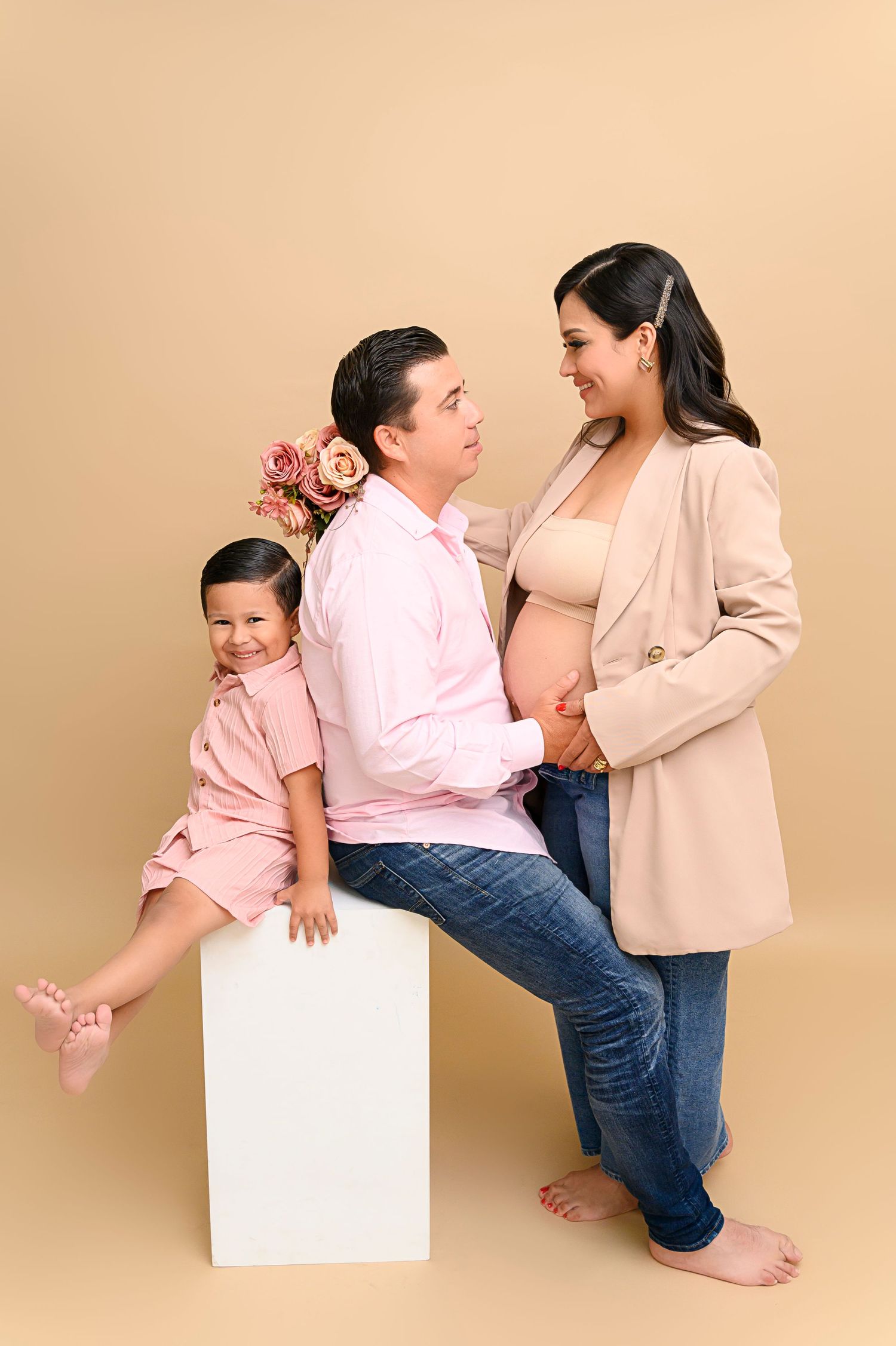 Minimalist family portrait series against beige backdrop in coordinating neutral outfits.