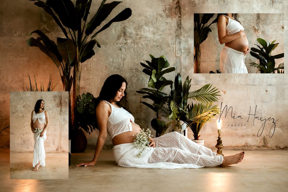 Indoor maternity session with tropical plants and white drapery creating an ethereal setting.