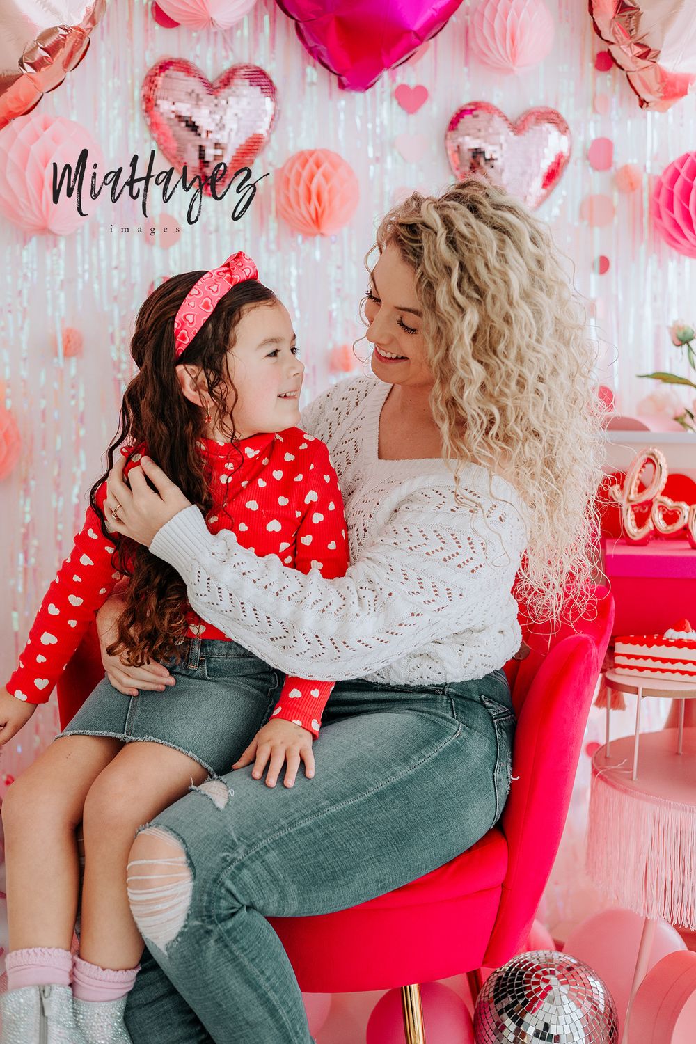 Valentine's Day themed photo session with pink and red heart decorations.