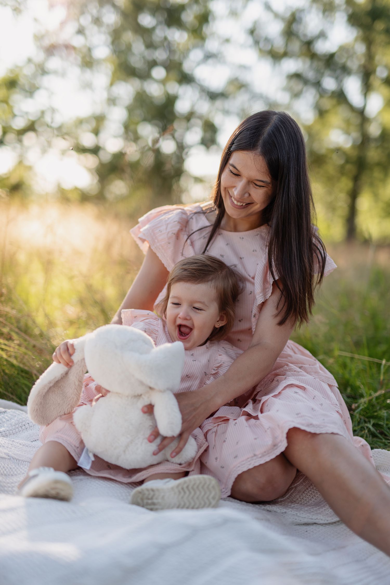 mamma-och-dotter-bland-gräs-och-guldigt-ljus