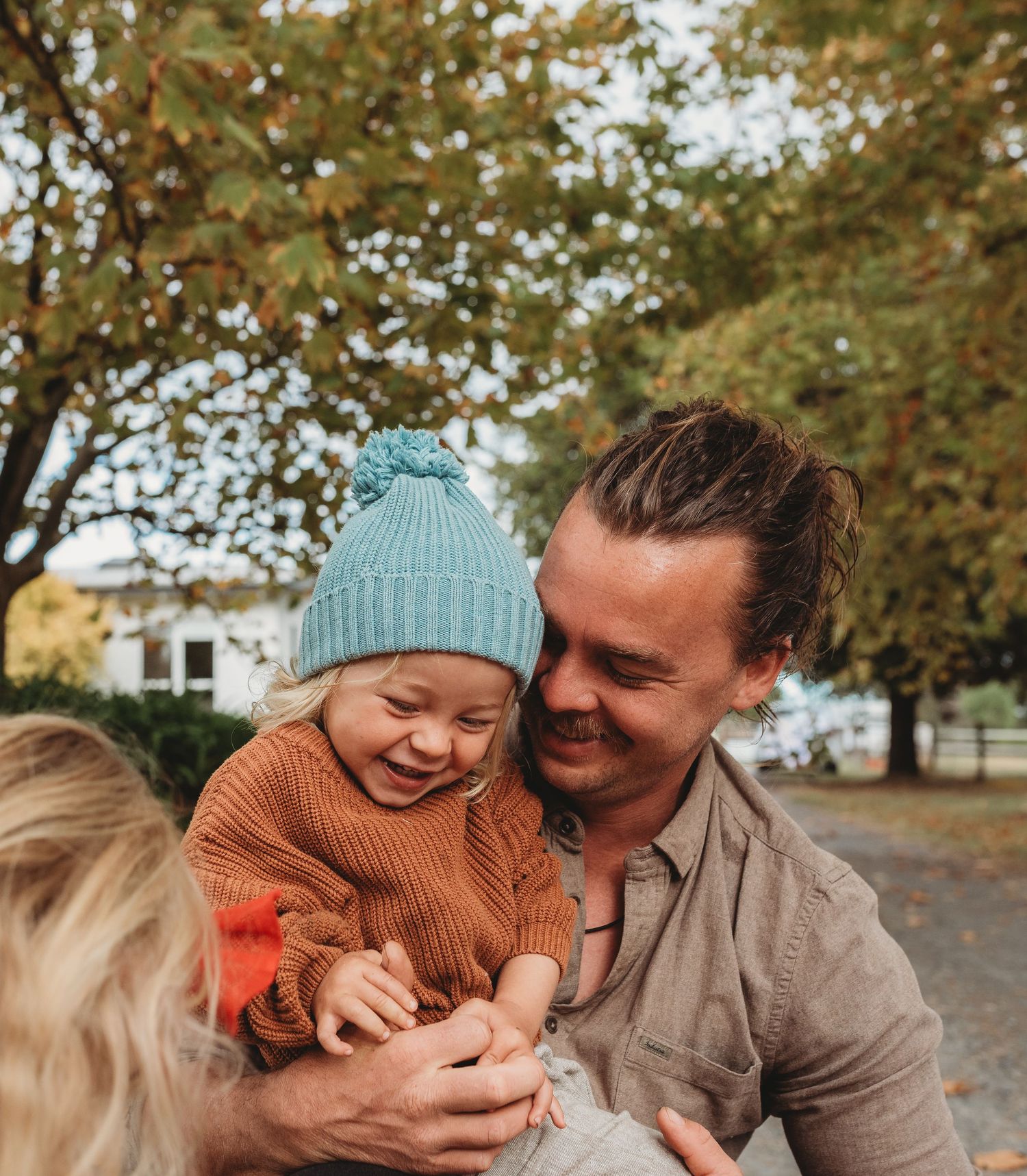 Family sharing joyful moment together in fall park setting.