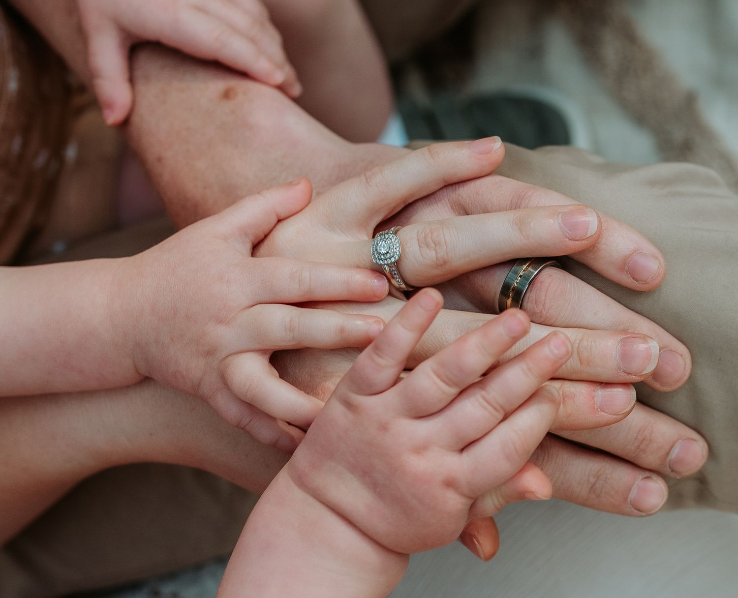 Close-up of hands tenderly touching in soft natural light.