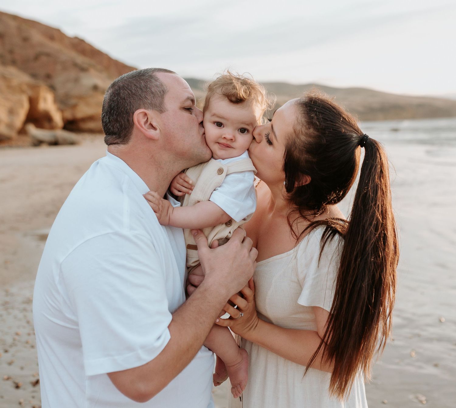 Intimate family moments captured during a beach photoshoot at sunset.