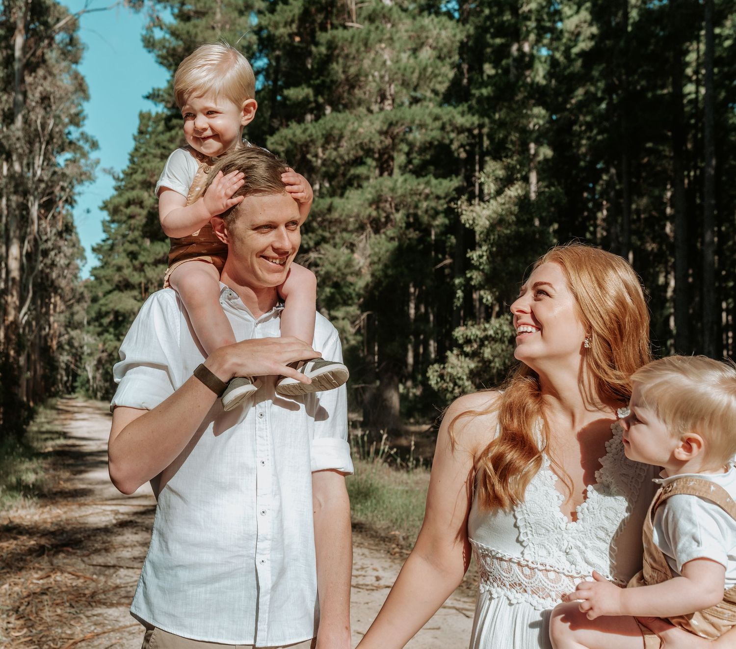 A tender family moment captured outdoors on a sunny day in nature.