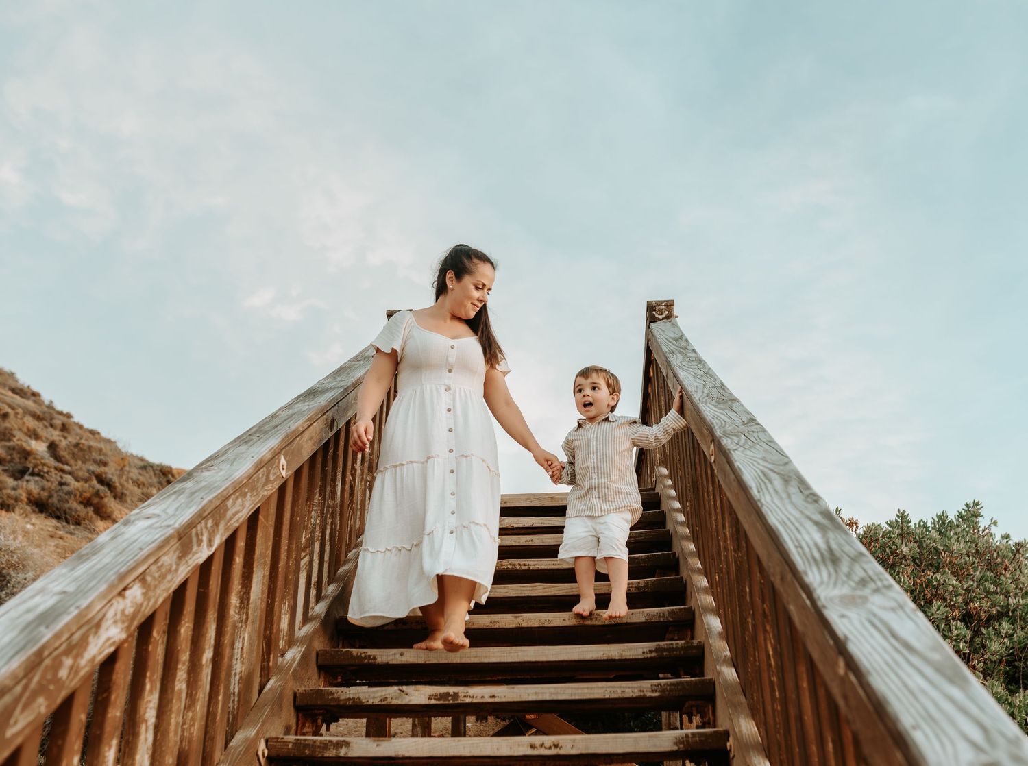 Panoramic view of wooden steps leading up a hillside against a blue sky.