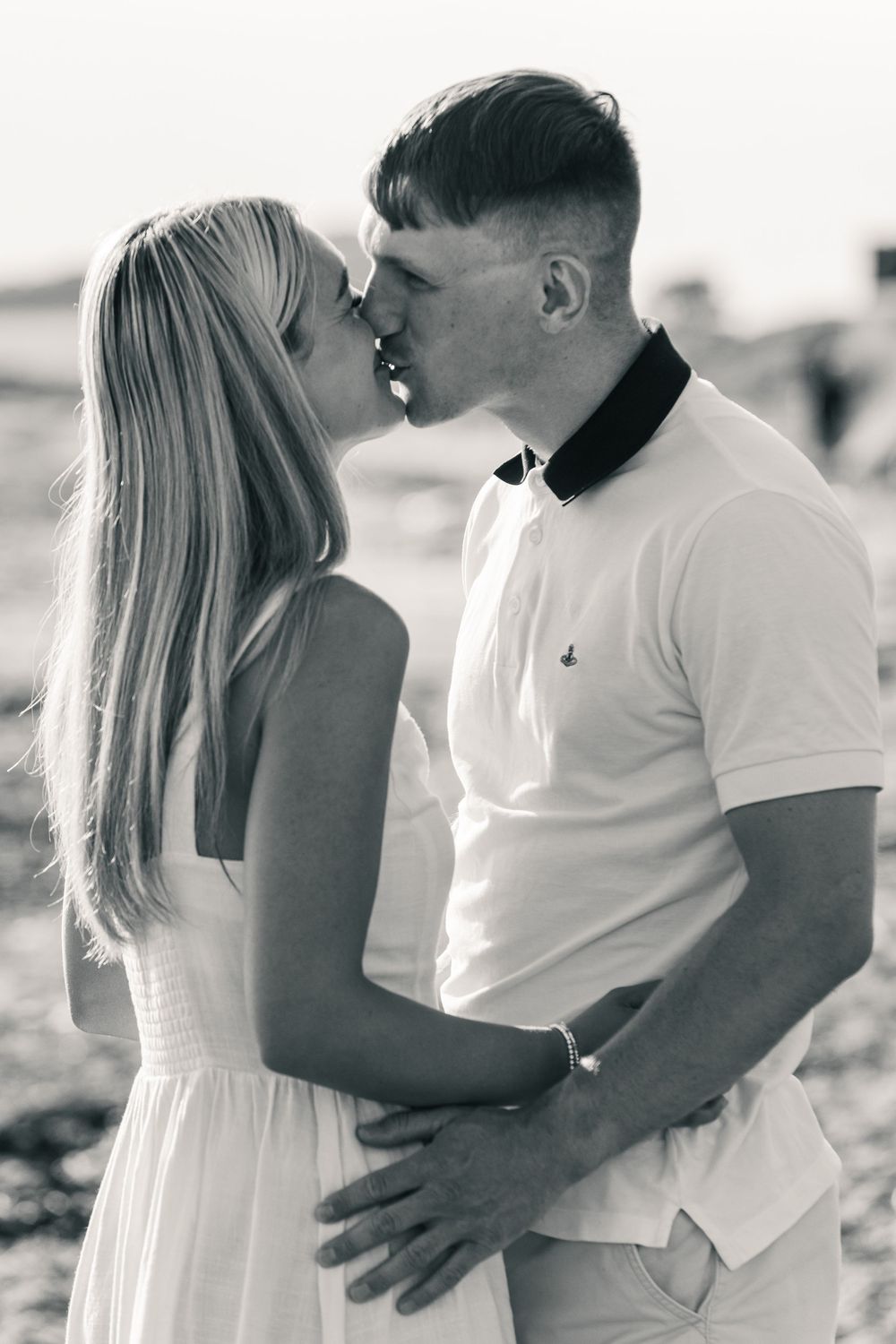 Black and white photo series of a romantic beach moment between a couple in summer attire.