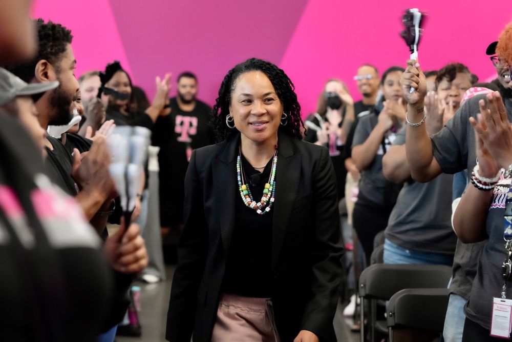 Dawn Staley walks through a crowd of cheering employees at a corporate event. T-Mobile