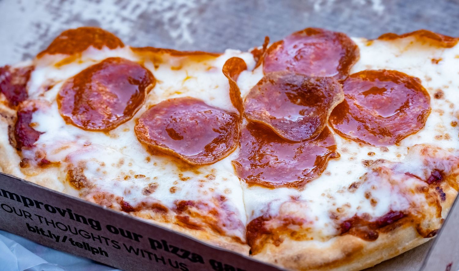 Close-up shot of pepperoni pizza with melted cheese and crispy crust.
