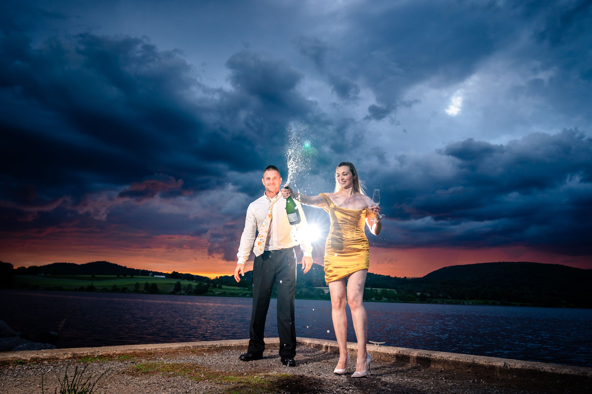 Dramatic sunset engagement photos with moody storm clouds creating a romantic atmosphere.