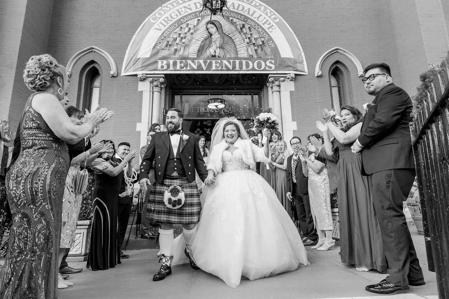 A joyful wedding ceremony exit at a historic church with guests celebrating.