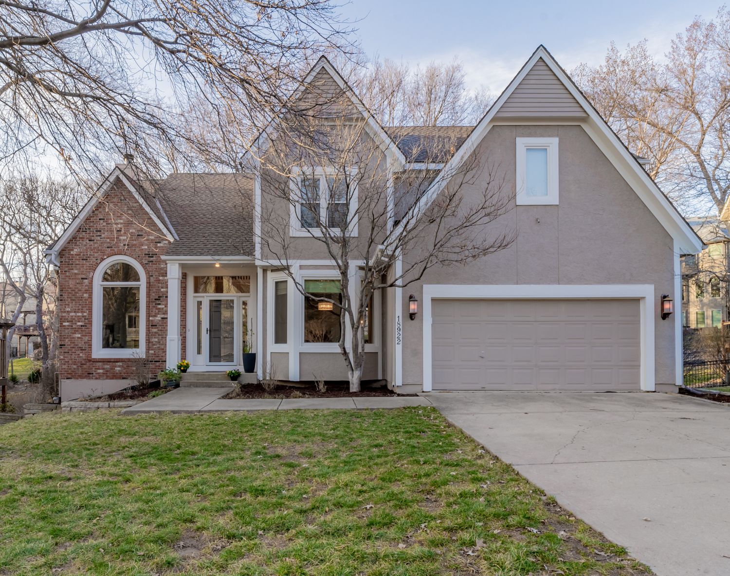 Front exterior of a two-story home with a lawn and attached garage, photographed by Cody Callaway Photography.