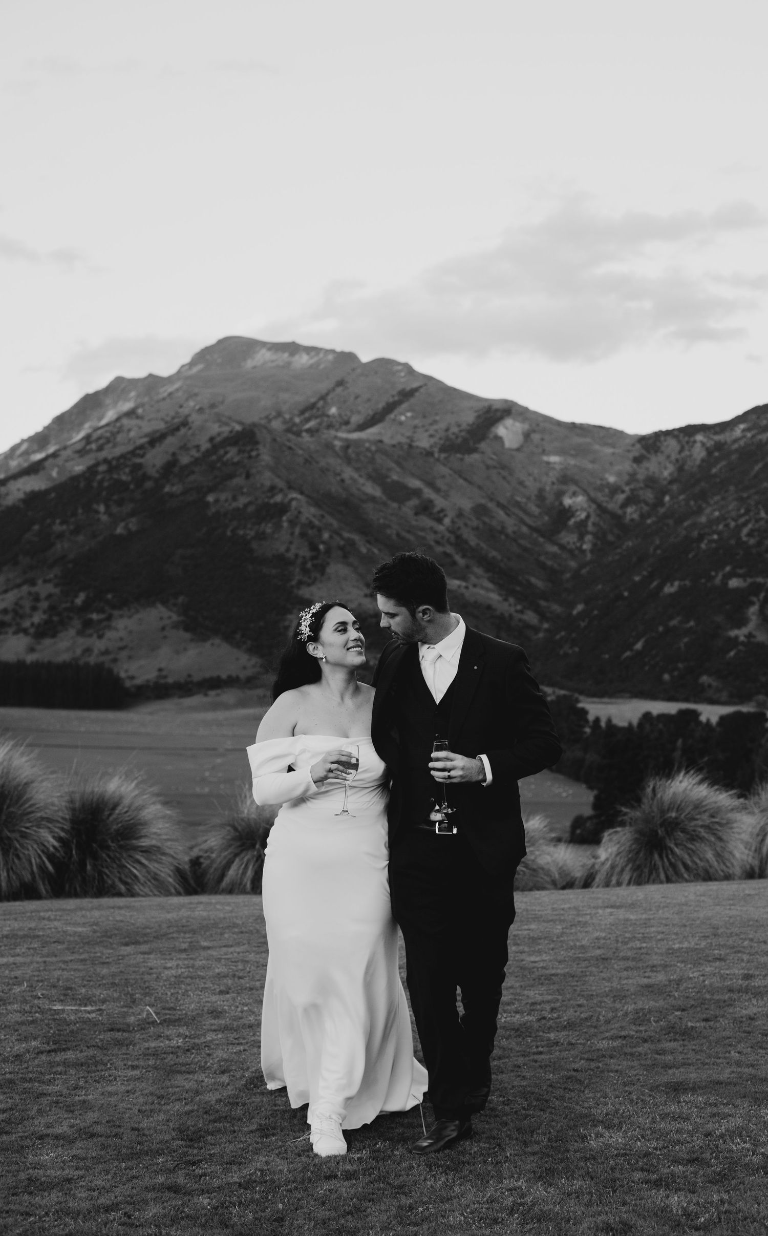 Black and white photo of bride and groom sharing a romantic moment with stunning mountain backdrop.