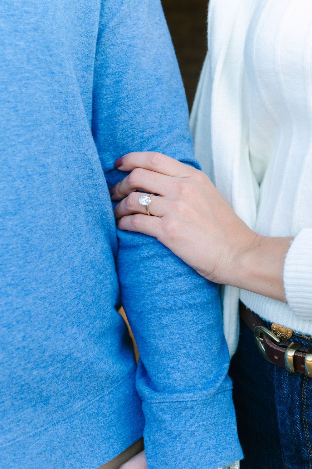 Close-up sequence showing hands adjusting a blue sweater sleeve.