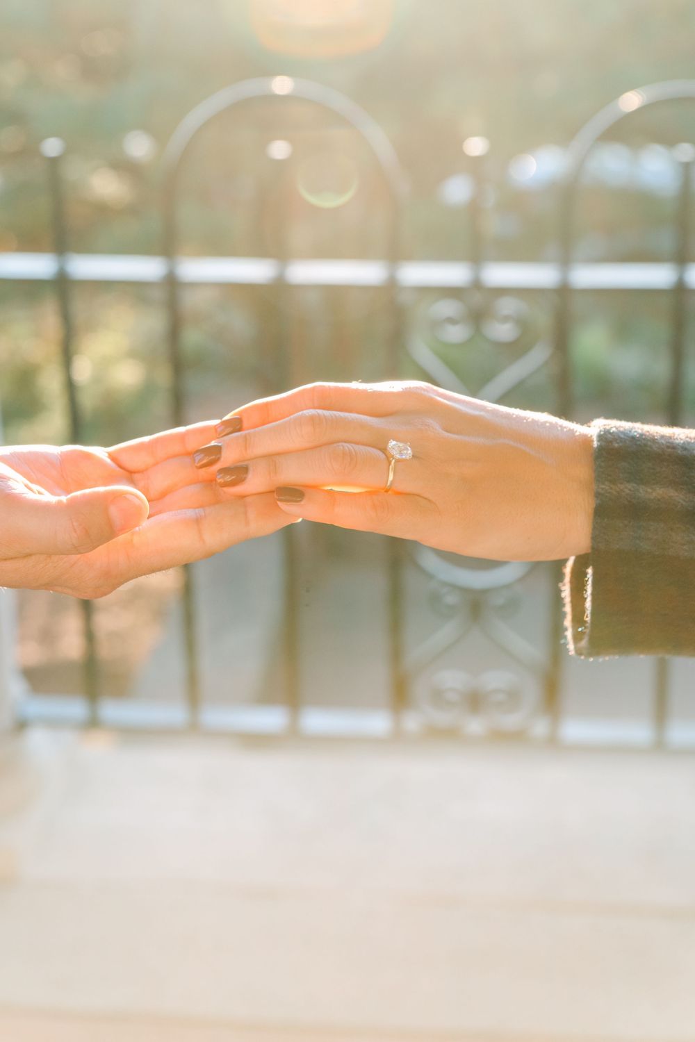 Hands reaching out and touching in a gentle, ethereal way against a soft blurred background.