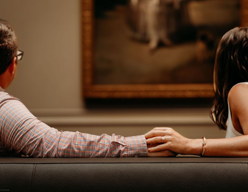 A couple admiring a painting during aDC Engagement photo session at the National Galleria.
