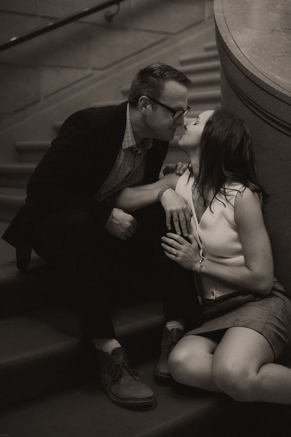 A romantic black and white photo of a couple sharing an intimate moment on stairs engagement session at the National Galleria Washington DC