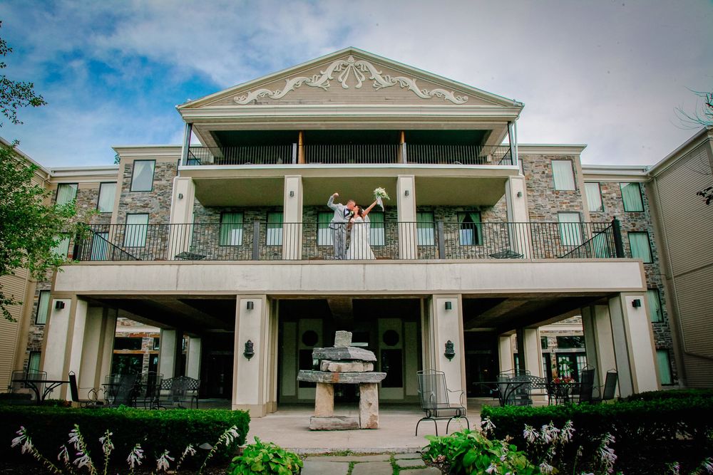 Niagara Falls Wedding Photography, Bride and Groom Pose at The Niagara Crossing Hotel on the balcony after their ceremony overlooking river