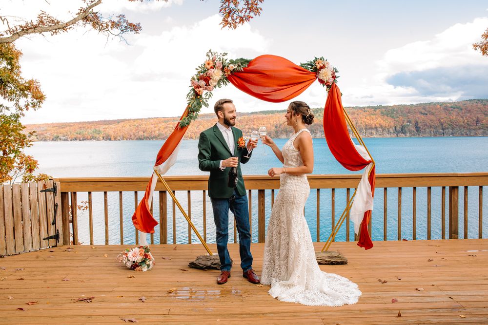 Buffalo and Rochester Elopement Photography. A wedding ceremony takes place on a wooden deck overlooking Canandaigua lake.