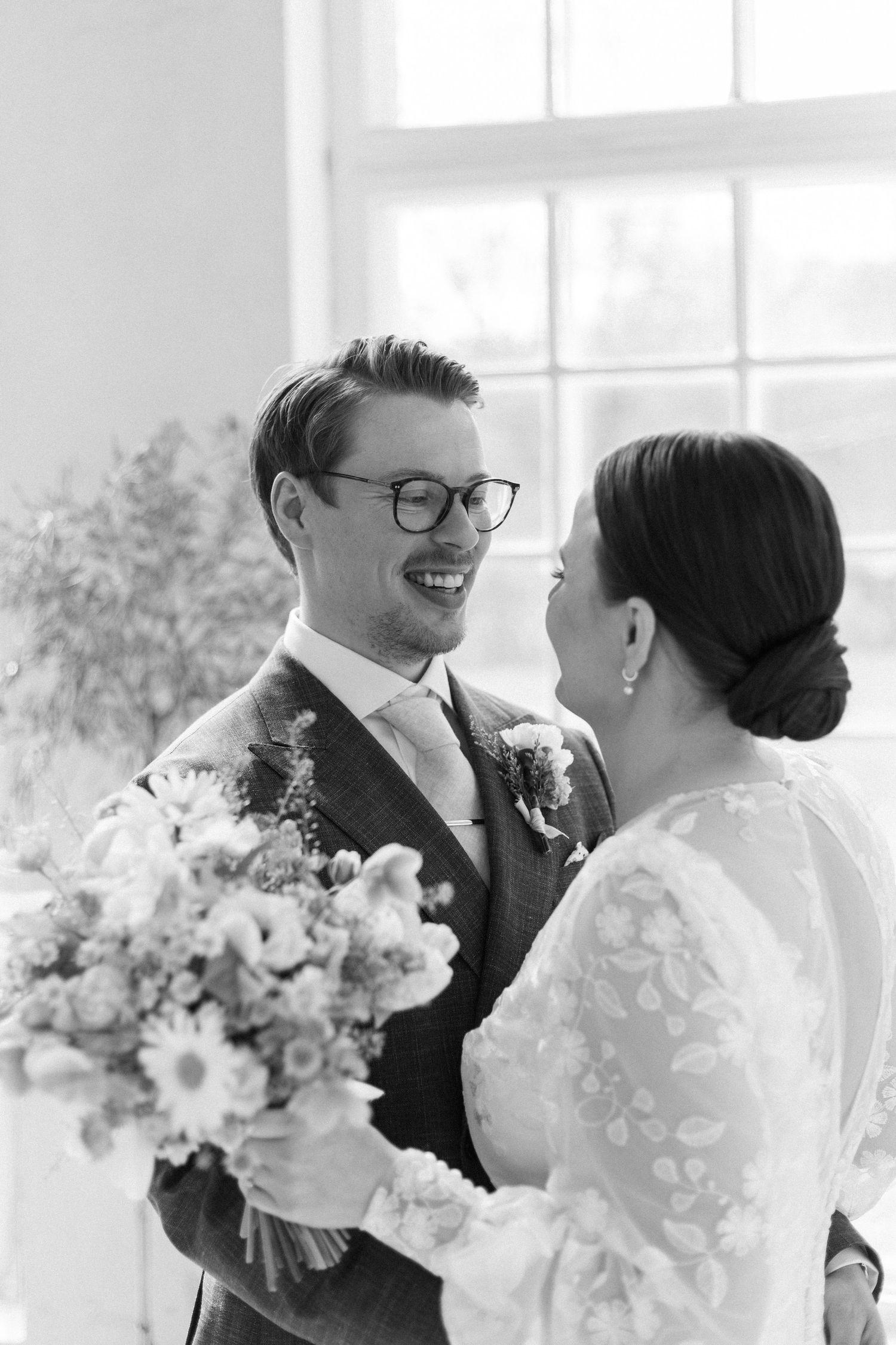 An intimate black and white portrait of a couple sharing a joyful moment.