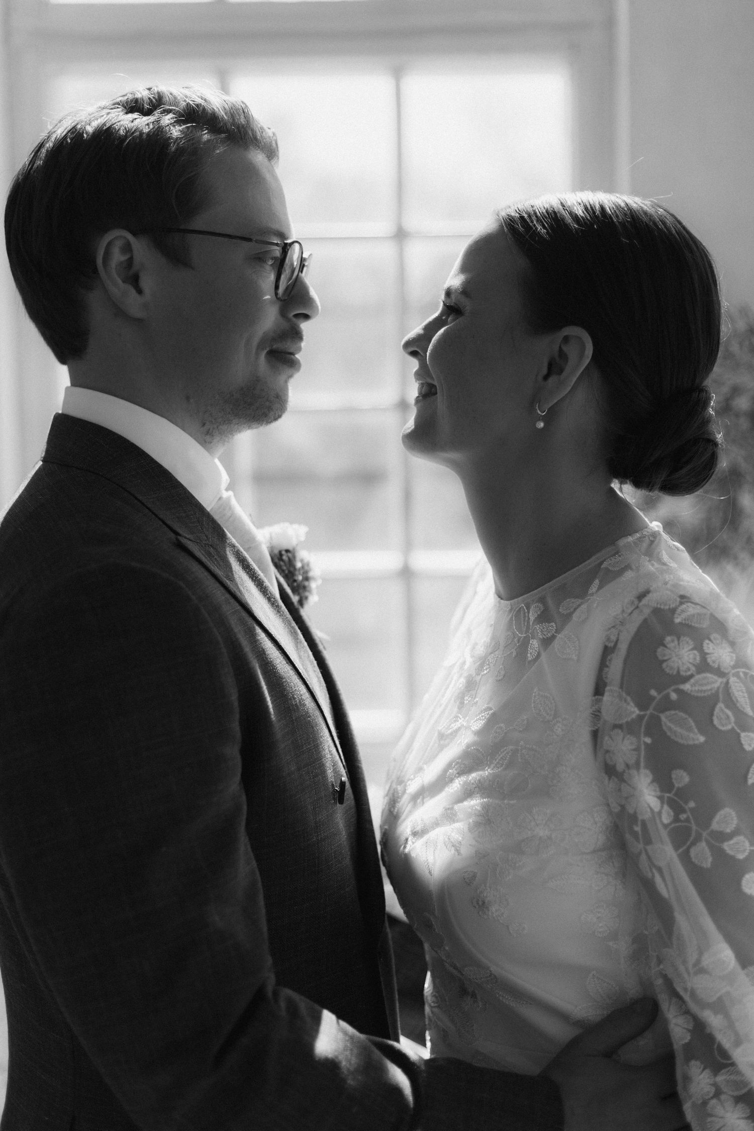 Intimate black and white portrait of newlyweds sharing a tender moment.